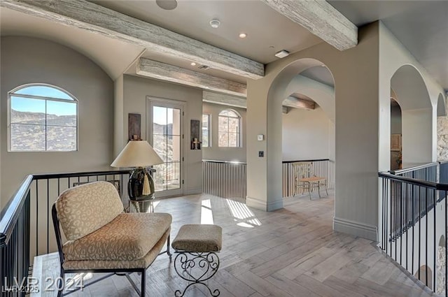 foyer entrance featuring beamed ceiling, parquet flooring, and baseboards