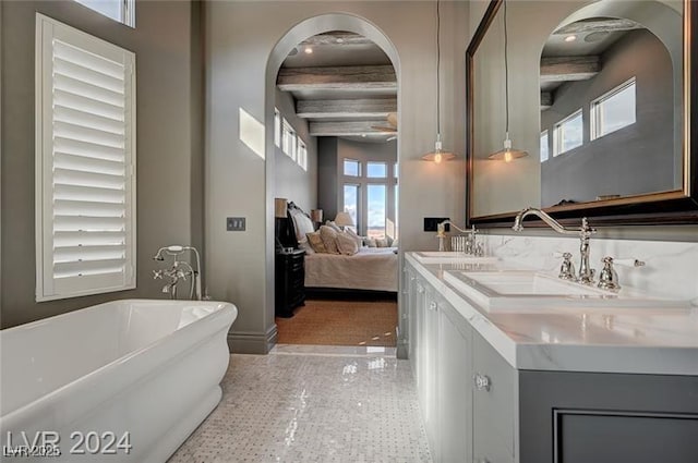 ensuite bathroom featuring double vanity, a soaking tub, beamed ceiling, ensuite bathroom, and a sink