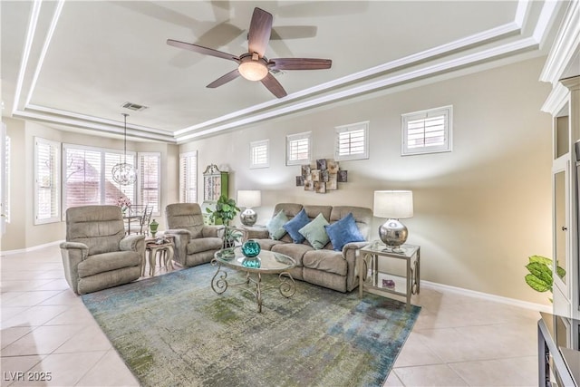 living area featuring a tray ceiling, crown molding, light tile patterned floors, a wealth of natural light, and visible vents