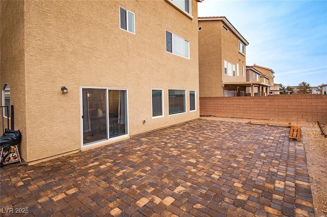 back of house with a tiled roof, fence, a patio, and stucco siding