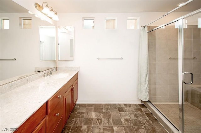 full bath featuring a shower stall, baseboards, and vanity