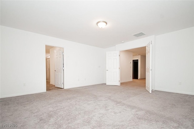 spare room with visible vents and light carpet