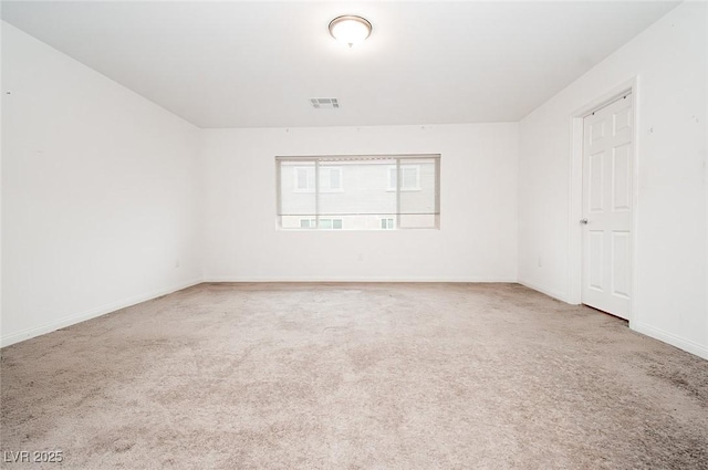 unfurnished room with carpet floors, visible vents, and baseboards