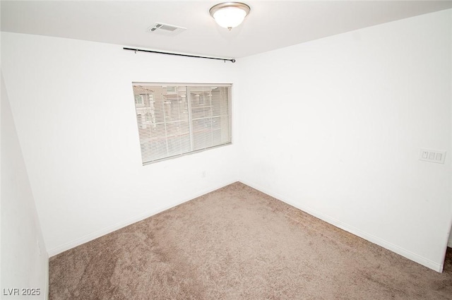 carpeted spare room with visible vents and baseboards