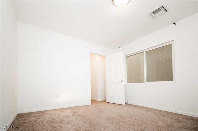 carpeted spare room with visible vents and baseboards