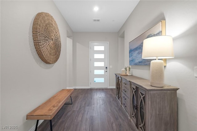 foyer entrance featuring dark wood finished floors, visible vents, and baseboards