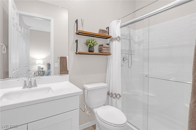 full bathroom featuring toilet, a stall shower, and vanity