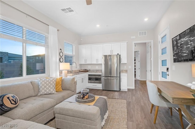 living area featuring visible vents, wood finished floors, and recessed lighting