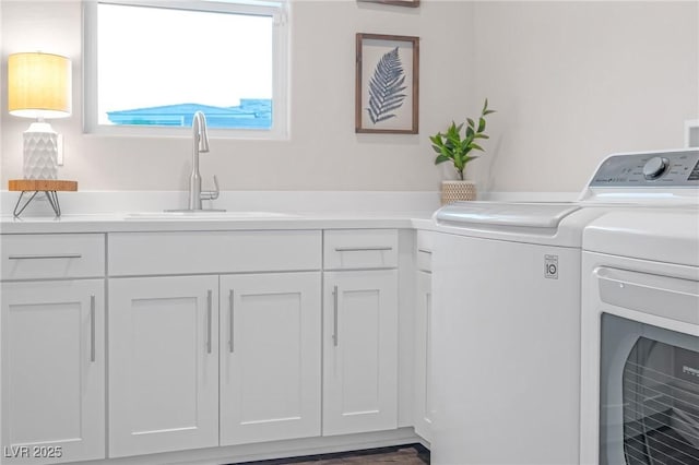 washroom featuring washer and clothes dryer, a sink, and cabinet space