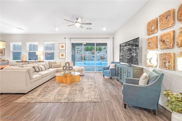 living area with visible vents, wood finished floors, and a ceiling fan