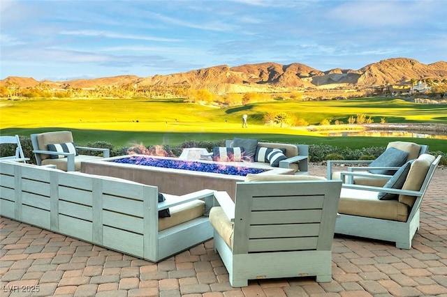 view of patio / terrace featuring a mountain view, golf course view, and an outdoor living space with a fire pit