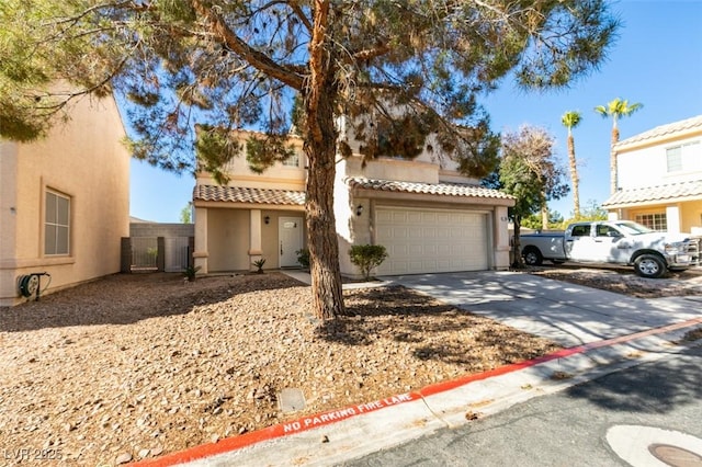 mediterranean / spanish-style house with a garage, concrete driveway, a tiled roof, and stucco siding