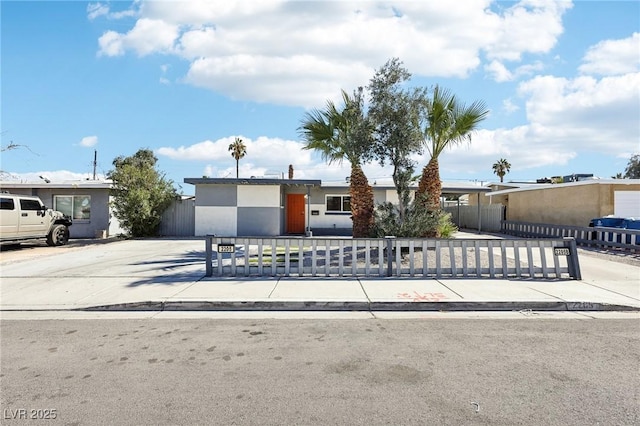 view of front of home featuring driveway, a fenced front yard, a gate, and stucco siding