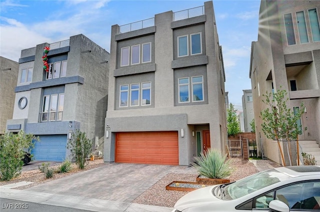 contemporary house with a garage, decorative driveway, and stucco siding