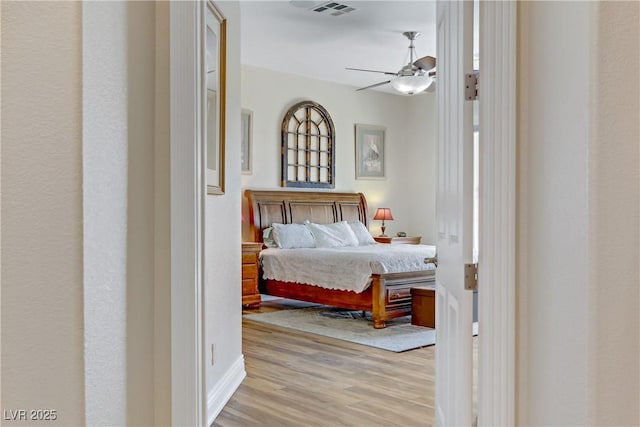 bedroom featuring wood finished floors, visible vents, and a ceiling fan