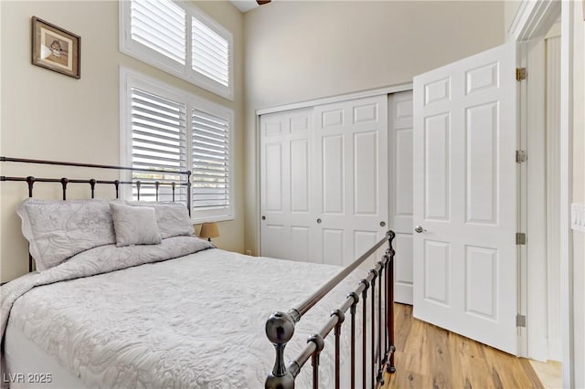 bedroom featuring multiple windows, a closet, and light wood-style flooring