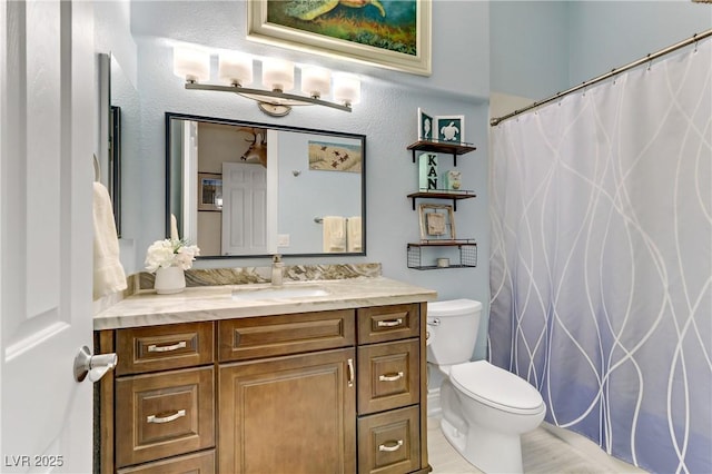 bathroom featuring a shower with shower curtain, vanity, and toilet