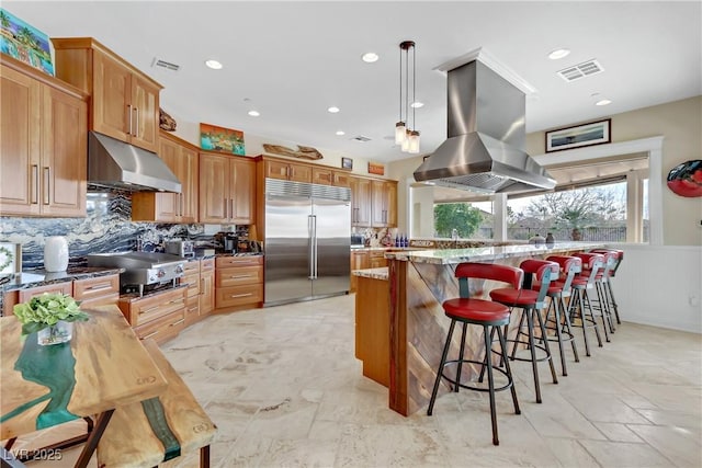 kitchen featuring island exhaust hood, visible vents, backsplash, appliances with stainless steel finishes, and under cabinet range hood