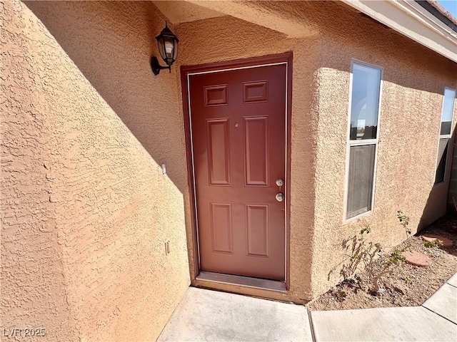 property entrance with stucco siding