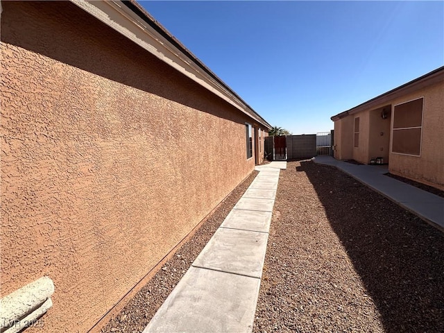 view of property exterior featuring fence and stucco siding