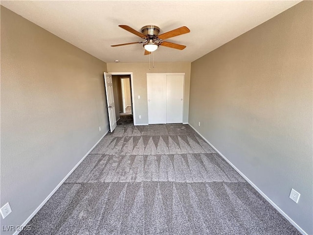 unfurnished bedroom featuring ceiling fan, a closet, dark carpet, and baseboards