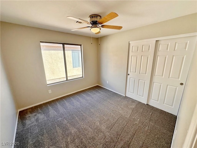 unfurnished bedroom featuring a ceiling fan, visible vents, baseboards, a closet, and dark carpet