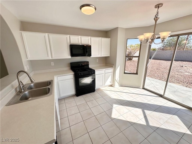 kitchen featuring decorative light fixtures, light countertops, black appliances, white cabinetry, and a sink