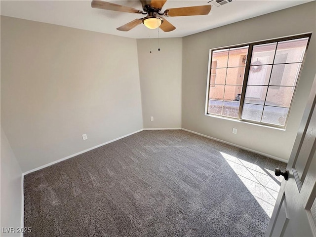 empty room with carpet, visible vents, ceiling fan, and baseboards