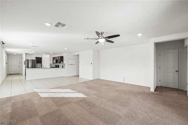 unfurnished living room with light carpet, recessed lighting, visible vents, and light tile patterned flooring