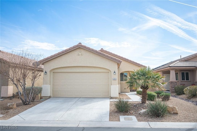 mediterranean / spanish-style house with concrete driveway, an attached garage, a tile roof, and stucco siding