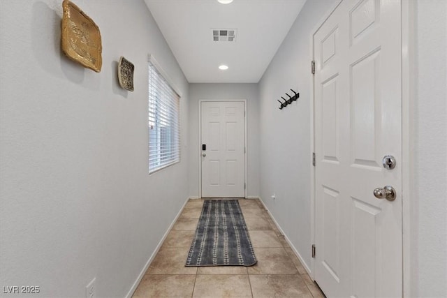 doorway featuring visible vents, baseboards, and light tile patterned floors