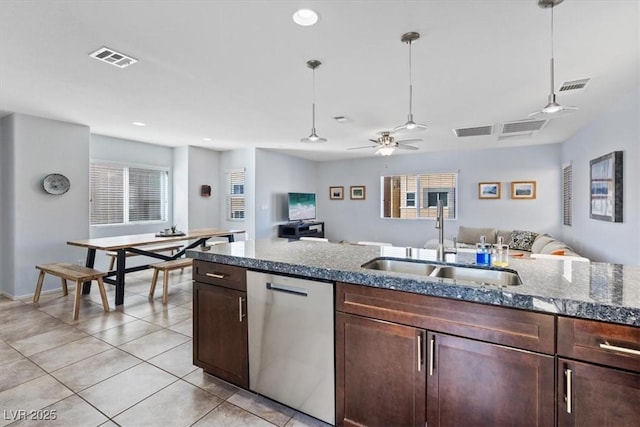 kitchen featuring visible vents, hanging light fixtures, open floor plan, a sink, and dishwasher