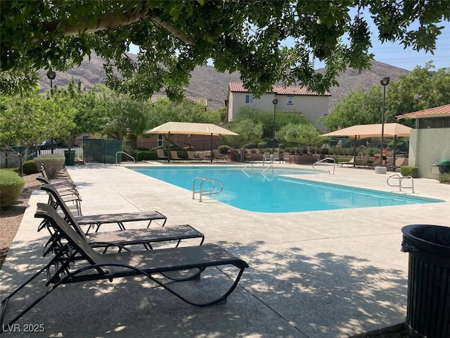 community pool with fence and a patio