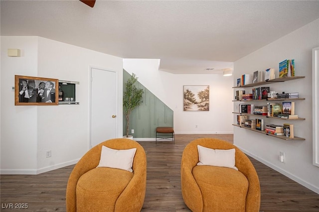 sitting room with dark wood-type flooring and baseboards