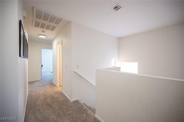 hall featuring baseboards, visible vents, carpet flooring, and an upstairs landing