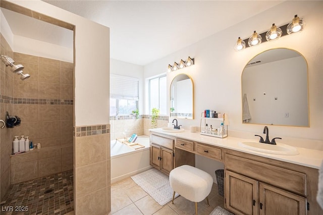 bathroom with tile patterned flooring, a garden tub, a sink, and walk in shower