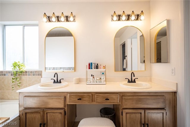 bathroom featuring a sink, a bathing tub, and double vanity