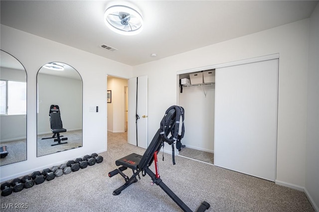 workout area featuring baseboards, visible vents, and carpet flooring