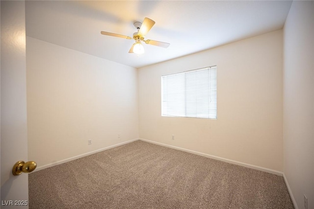 carpeted spare room featuring a ceiling fan and baseboards