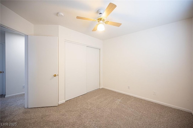 unfurnished bedroom with baseboards, carpet, a ceiling fan, and a closet