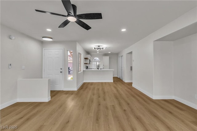 unfurnished living room featuring light wood-type flooring, baseboards, a ceiling fan, and recessed lighting