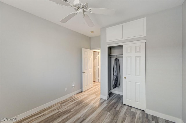 unfurnished bedroom featuring ceiling fan, a closet, light wood-type flooring, and baseboards