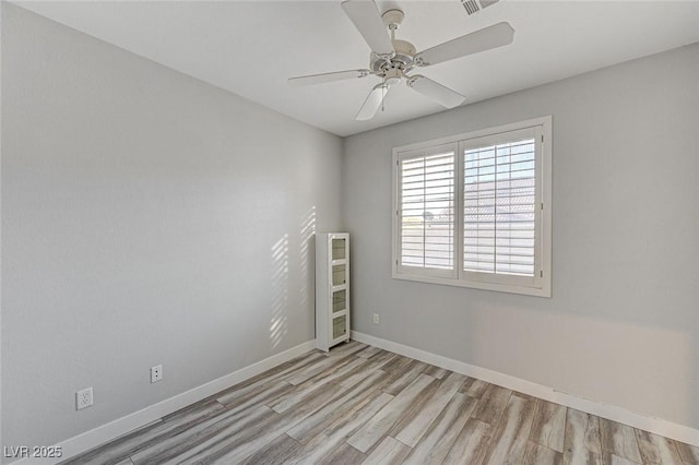 unfurnished room with light wood-style floors, baseboards, and a ceiling fan