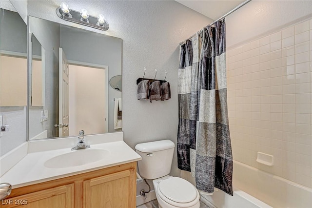 bathroom featuring toilet, a textured wall, shower / tub combo with curtain, and vanity