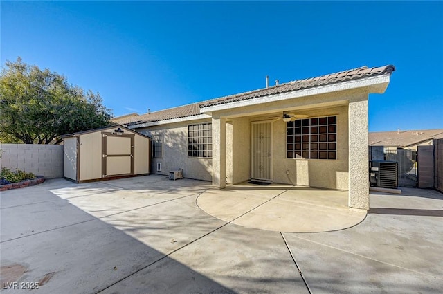 back of house featuring a patio, a storage unit, an outdoor structure, and stucco siding