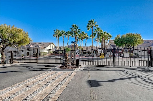 view of road with a residential view, a gate, curbs, and a gated entry