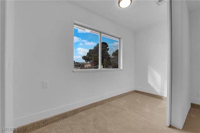 unfurnished room featuring carpet and baseboards