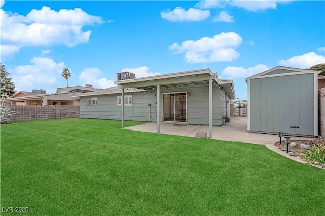 back of house featuring an outbuilding, a patio, fence, a lawn, and a shed