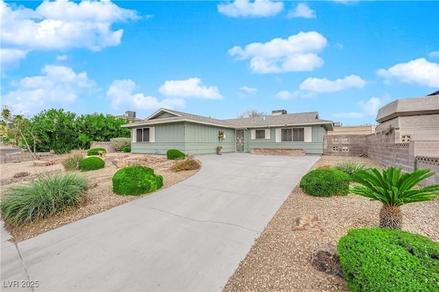 single story home featuring fence and concrete driveway