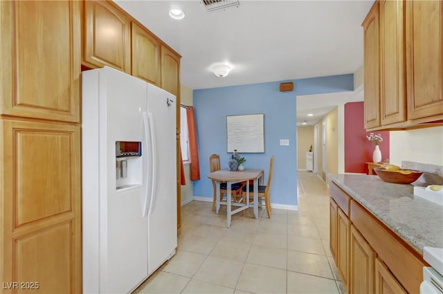 kitchen with white refrigerator with ice dispenser, visible vents, light tile patterned floors, and recessed lighting